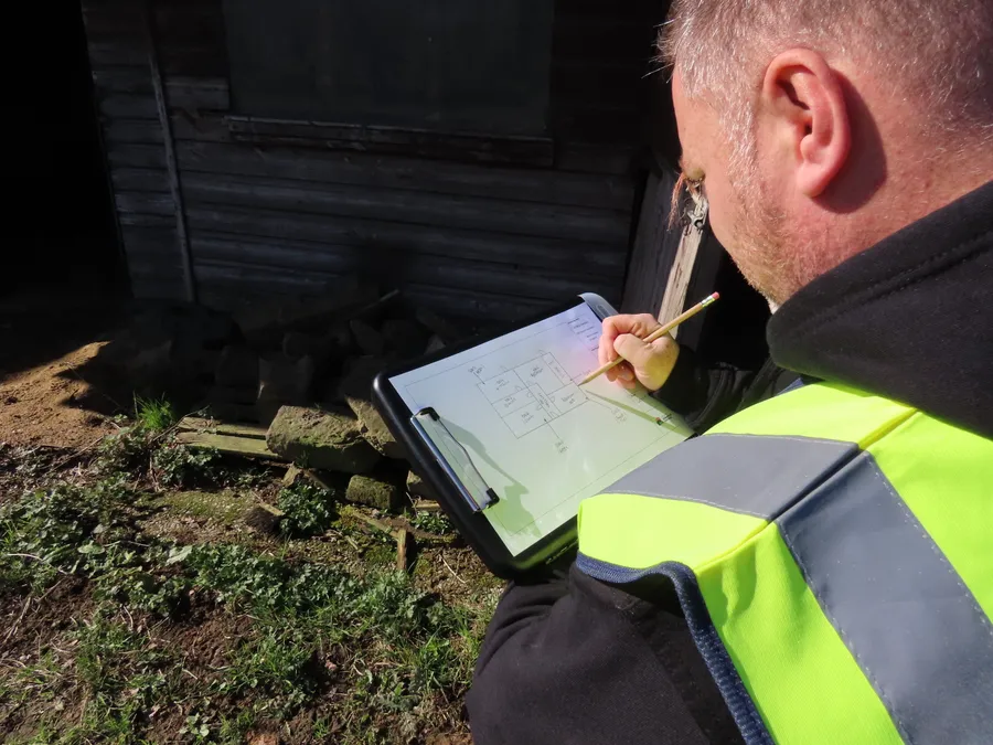 A qualified asbestos surveyor records the layout and findings of an outbuilding during an asbestos survey in Yorkshire.