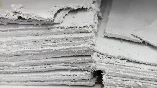 Stacked asbestos insulating board (AIB) panels showing exposed, damaged and fibrous edges. AIB is a higher-risk asbestos material that can release fibres when broken, cut or disturbed.