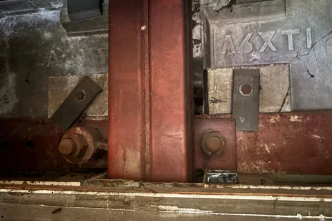 Exposed structural steel column within the CLASP-built Ossett Academy, showing the area where asbestos insulating board packers were identified during the refurbishment survey.