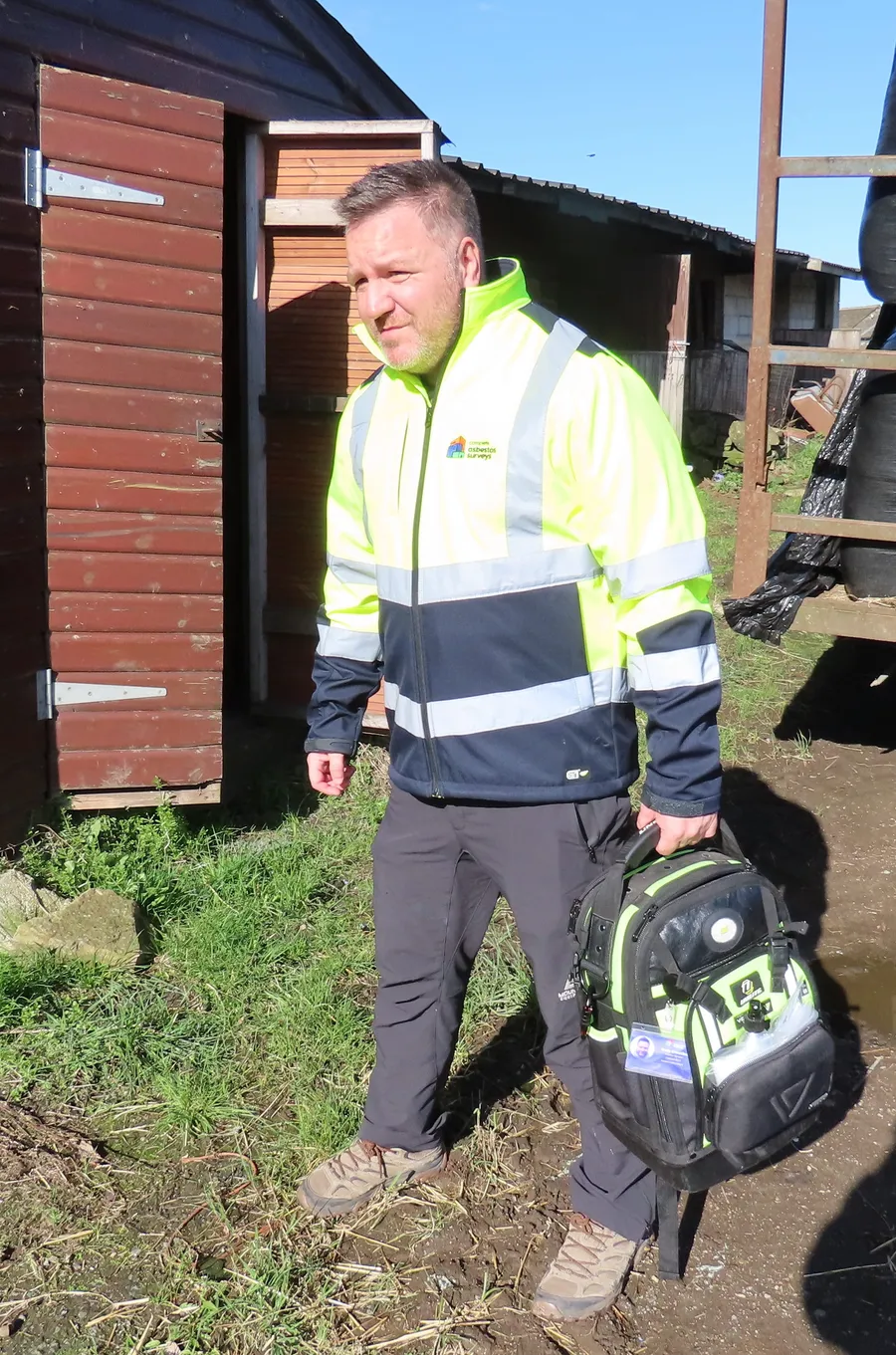 A qualified asbestos surveyor carrying specialist inspection equipment arrives to conduct an asbestos survey at an agricultural property in Yorkshire.