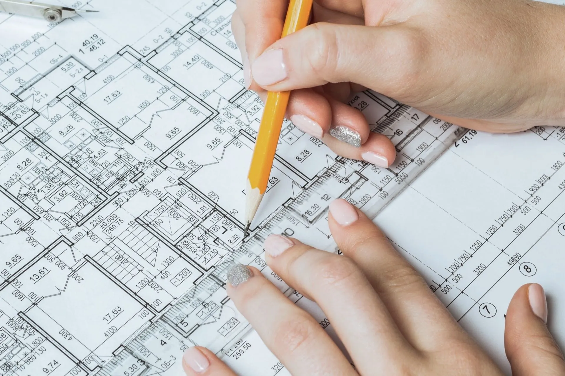 Building floor plans marked up with a pencil and scale rule while an asbestos management plan is drawn up