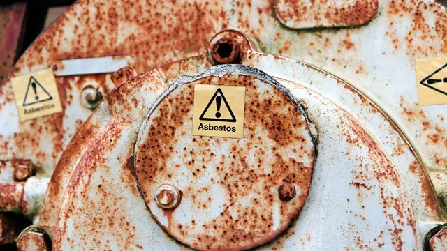 Asbestos-containing woven rope seal fitted around an industrial boiler or machinery access door. These heat-resistant seals can release fibres if worn, removed or disturbed.