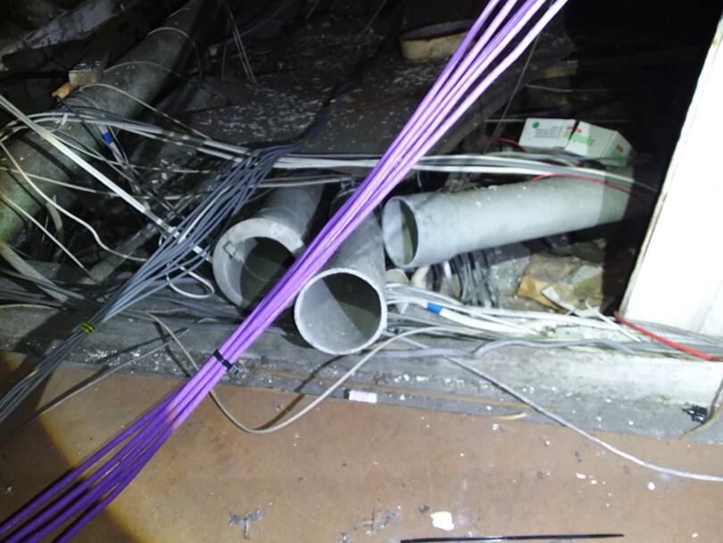 Asbestos cement flue pipes stored loose in loft of commercial unit