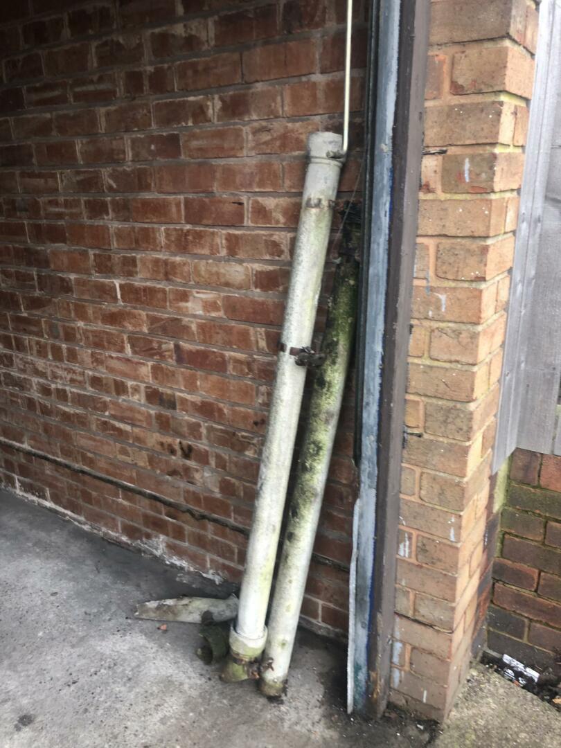 Asbestos cement rainwater pipes stored in garage