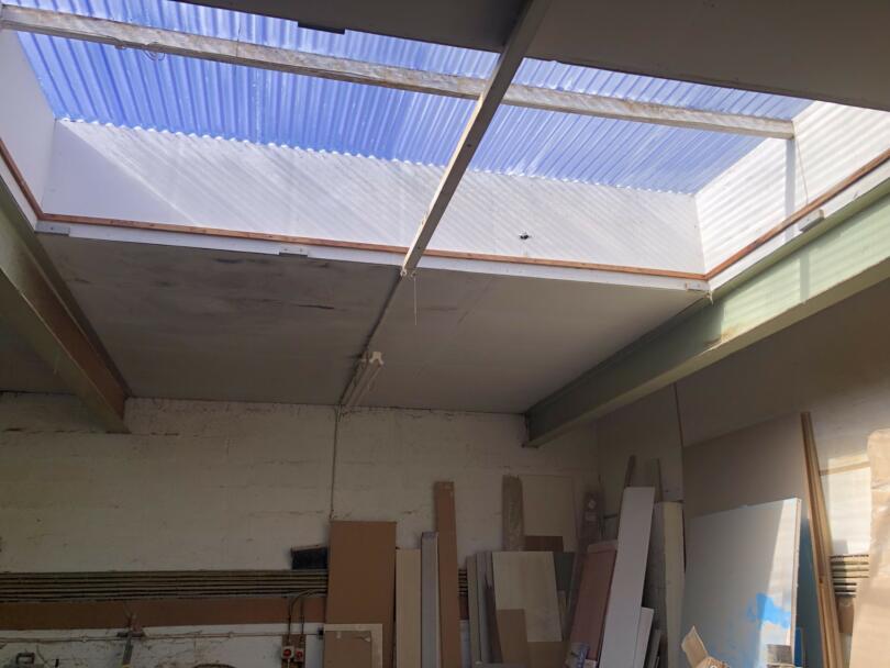 Asbestos insulating board ceiling panels and panels around skylight in joiners workshop