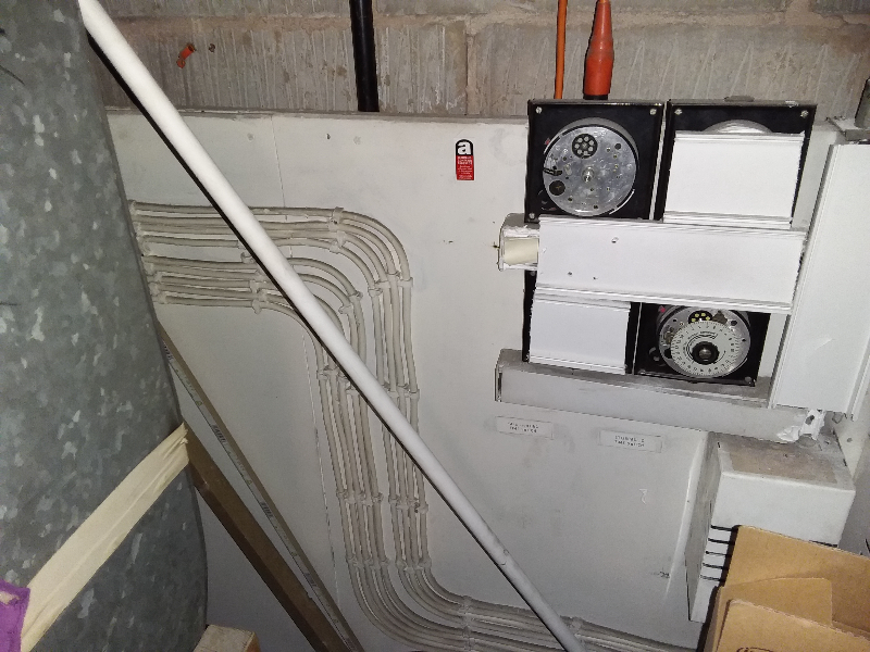 Asbestos insulating board panel behind electrics
