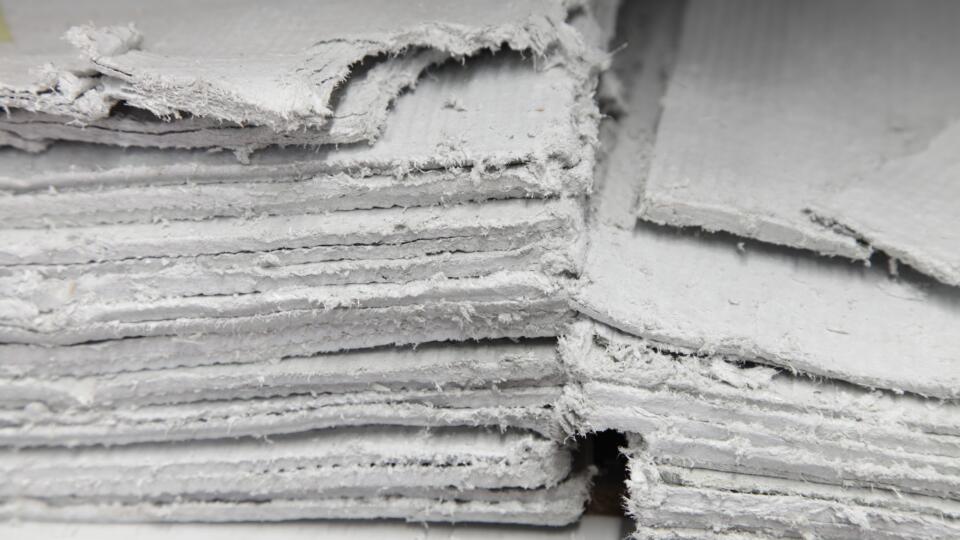 Asbestos insulating board (AIB) stacked in piles and in poor condition