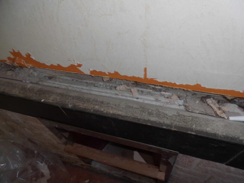 Asbestos insulating board panels wedged behind fire place