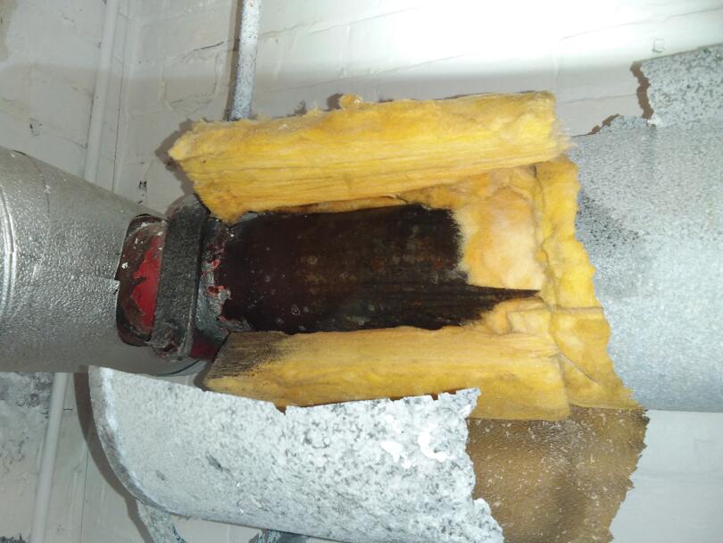 Asbestos insulation debris on pipe work within school boiler room