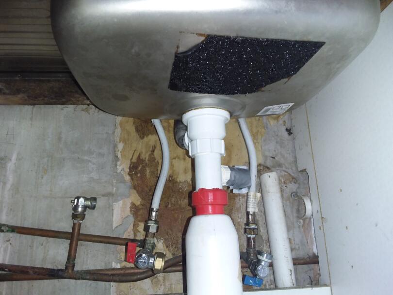 Asbestos bitumen sink pad in kitchen cupboard
