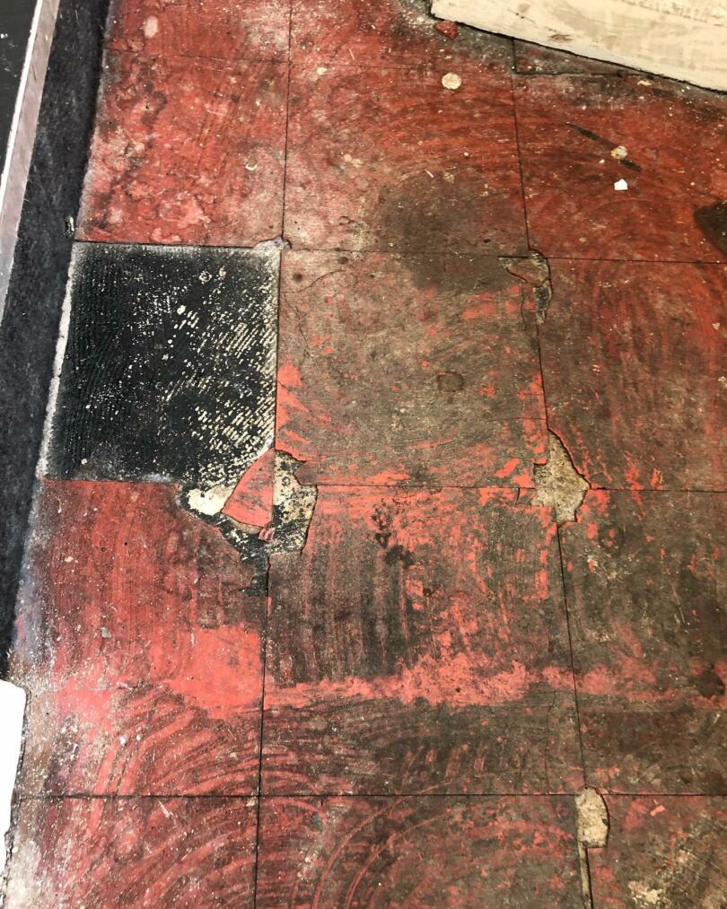 Red asbestos vinyl floor tiles damaged and asbestos containing adhesive