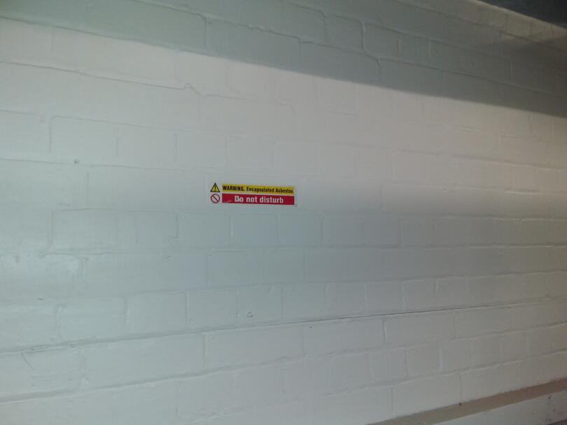 Warning sign on encapsulated walls within boiler room