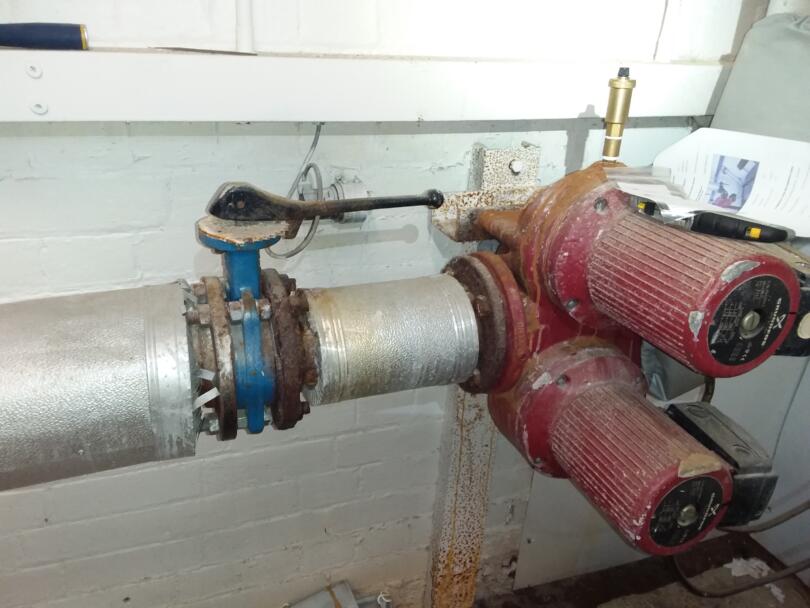 Asbestos gaskets on heating pipe flanges in school boiler room