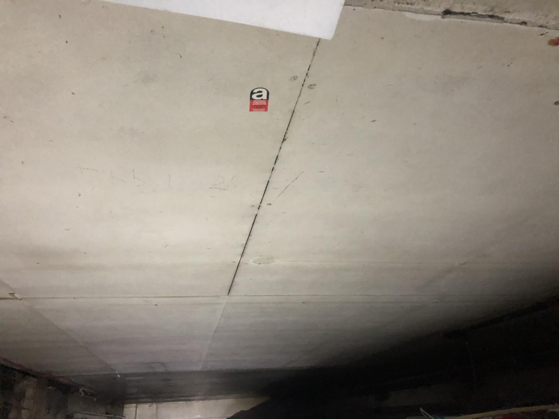 Asbestos insulating board ceiling panels with warning label sticker