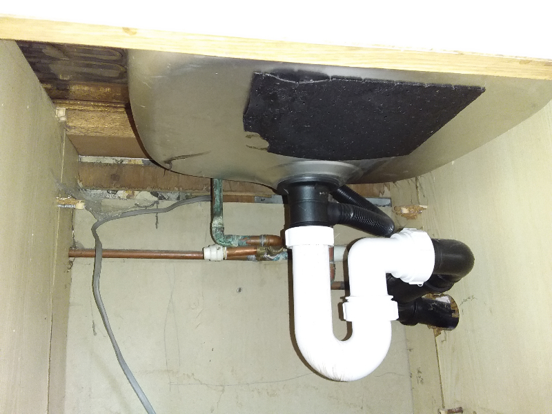 Asbestos sink pad on underside of kitchen sink