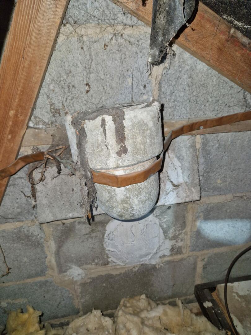 Redundant asbestos cement flue pipe bend in loft
